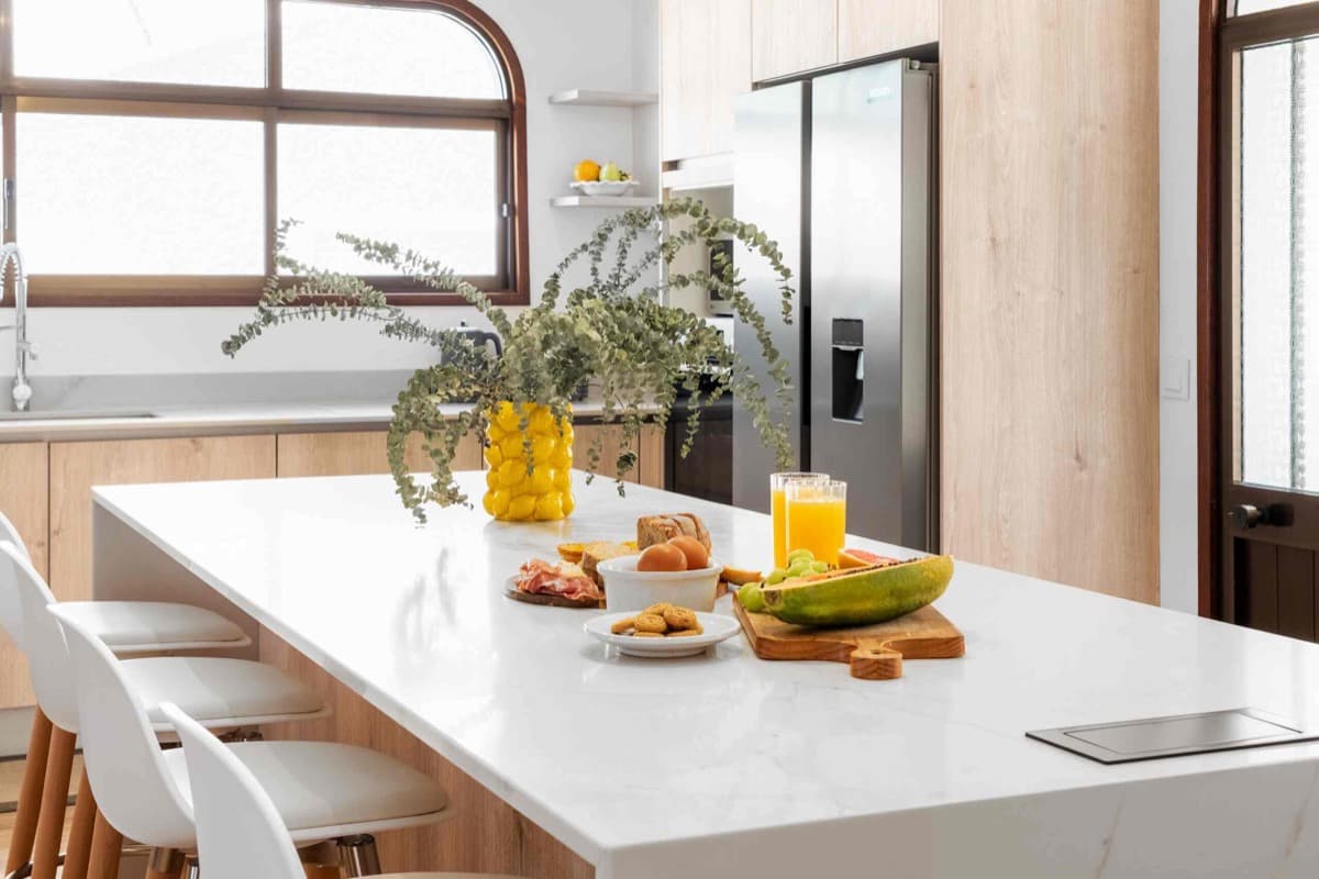 The kitchen island laid with breakfast, fruit, and juice.